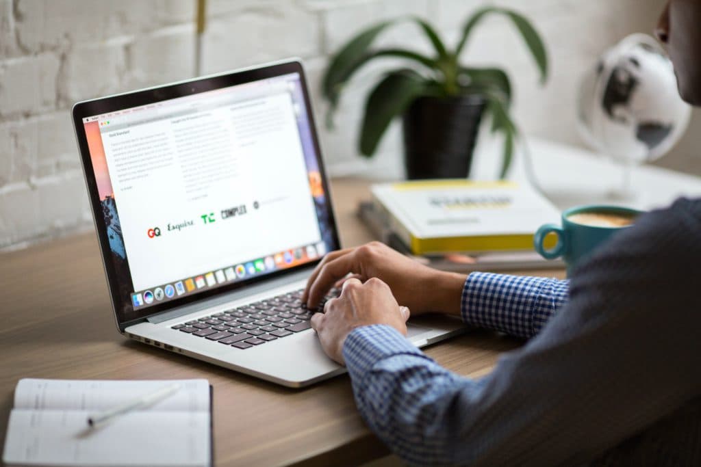 A man reads articles on his laptop while preparing for a brainstorming session.