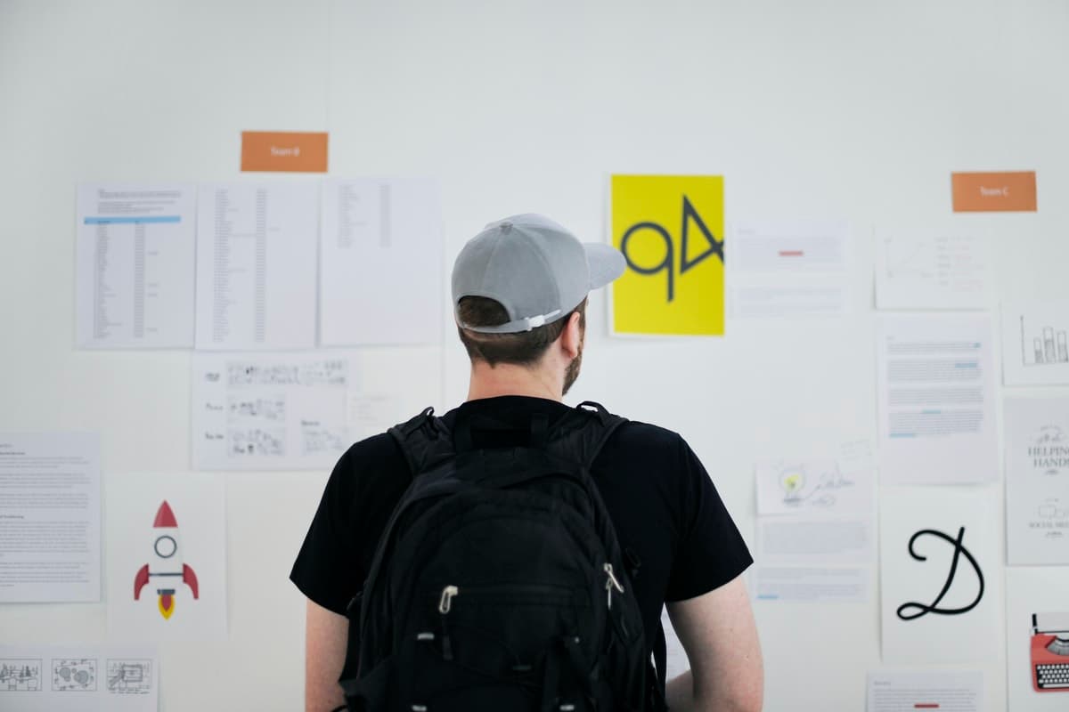 A man reviews designs and notes on the wall during part of the agile planning process.