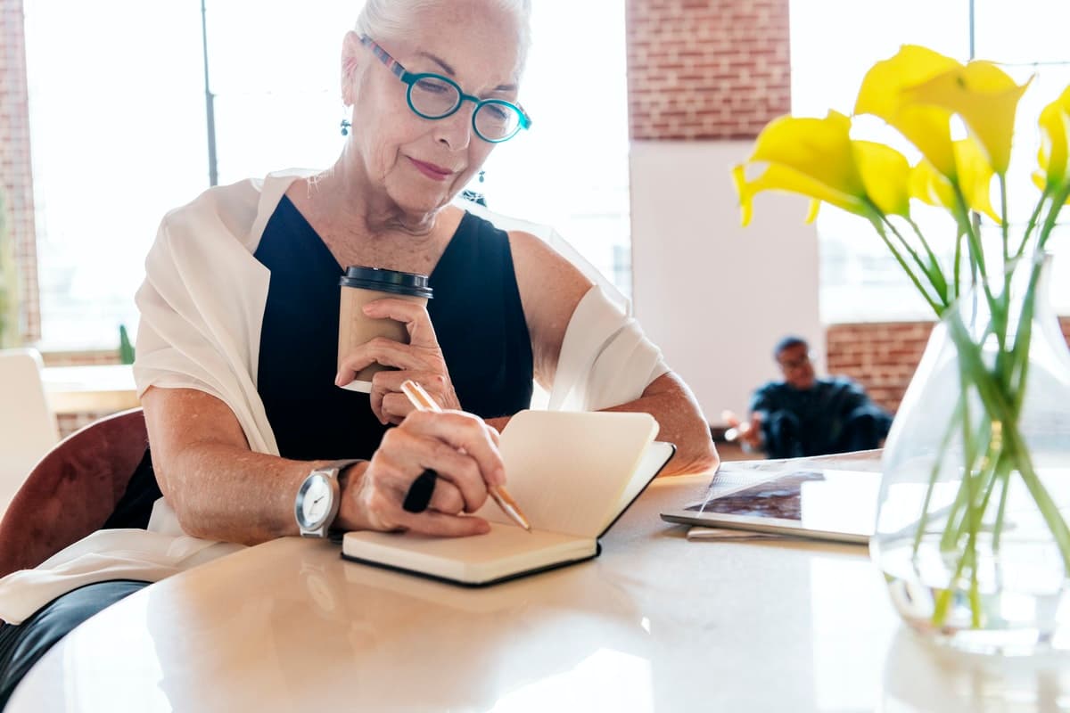 A woman writes down ideas while brainstorming ways to design an interactive presentation.