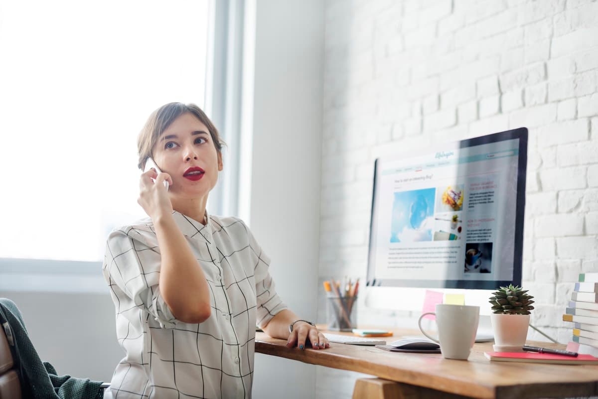 A woman working for a remote-first company takes a call while working in her home office.