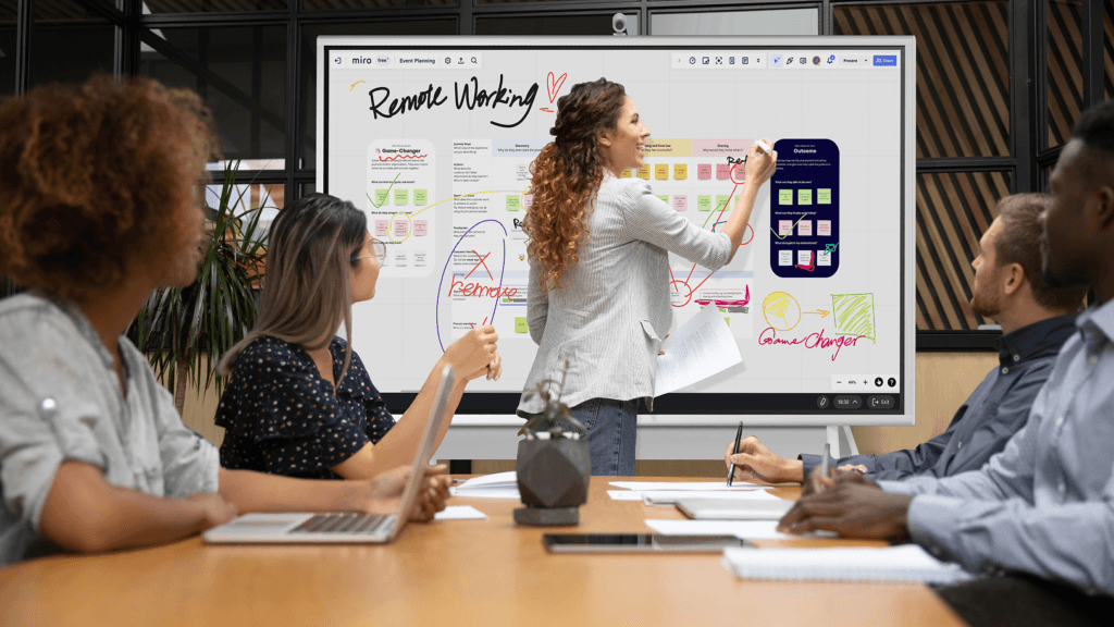 Team collaboration meeting using  Vibe Smart Whiteboard for idea sharing and visual communication in office setting.