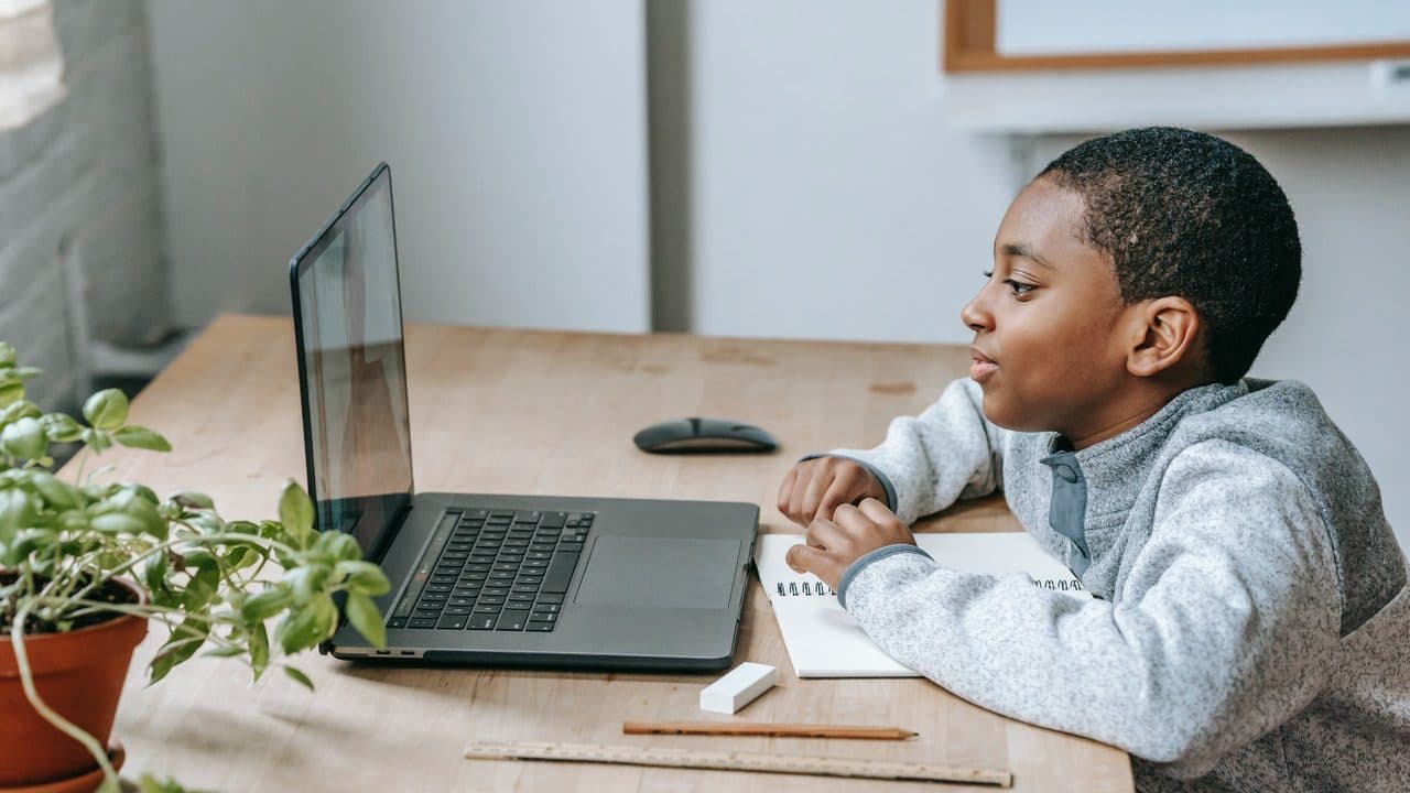 A young boy watches an online math lesson as part of his distance learning curriculum.