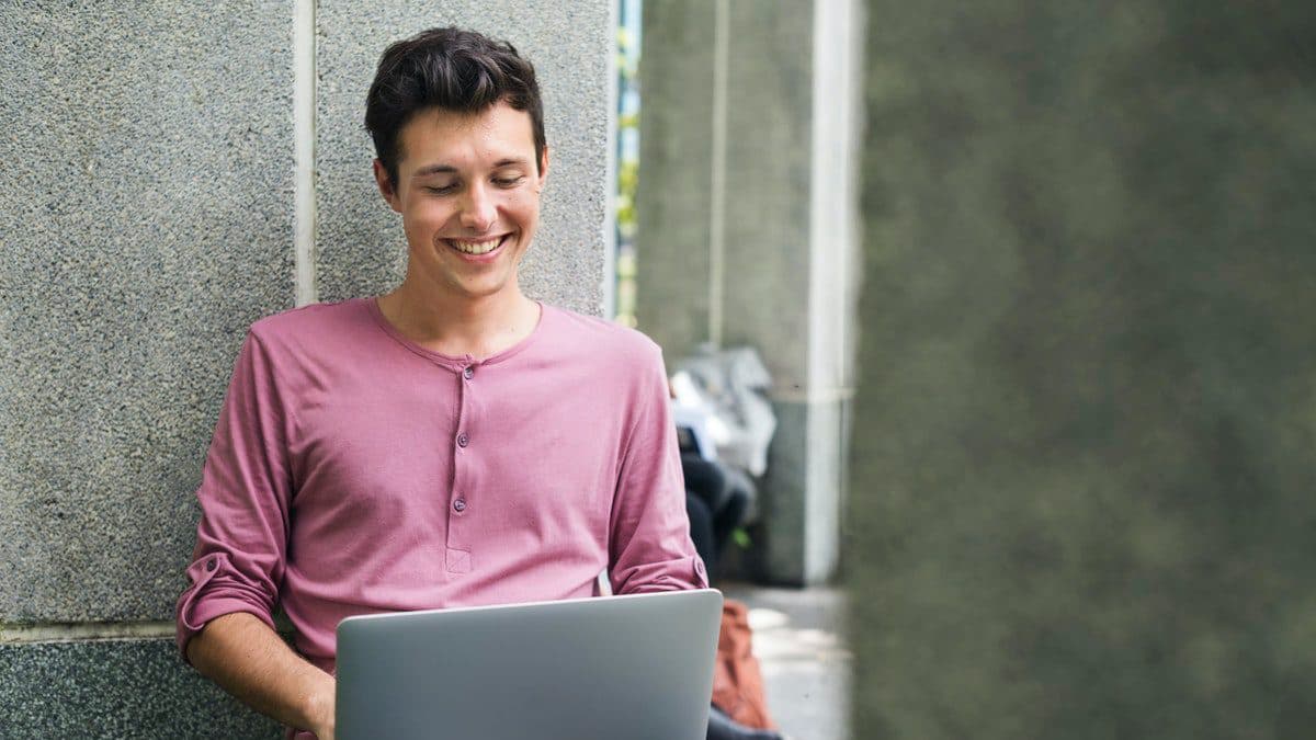 A student uses his laptop during a one-on-one meeting with his instructor, following distance learning best practices.
