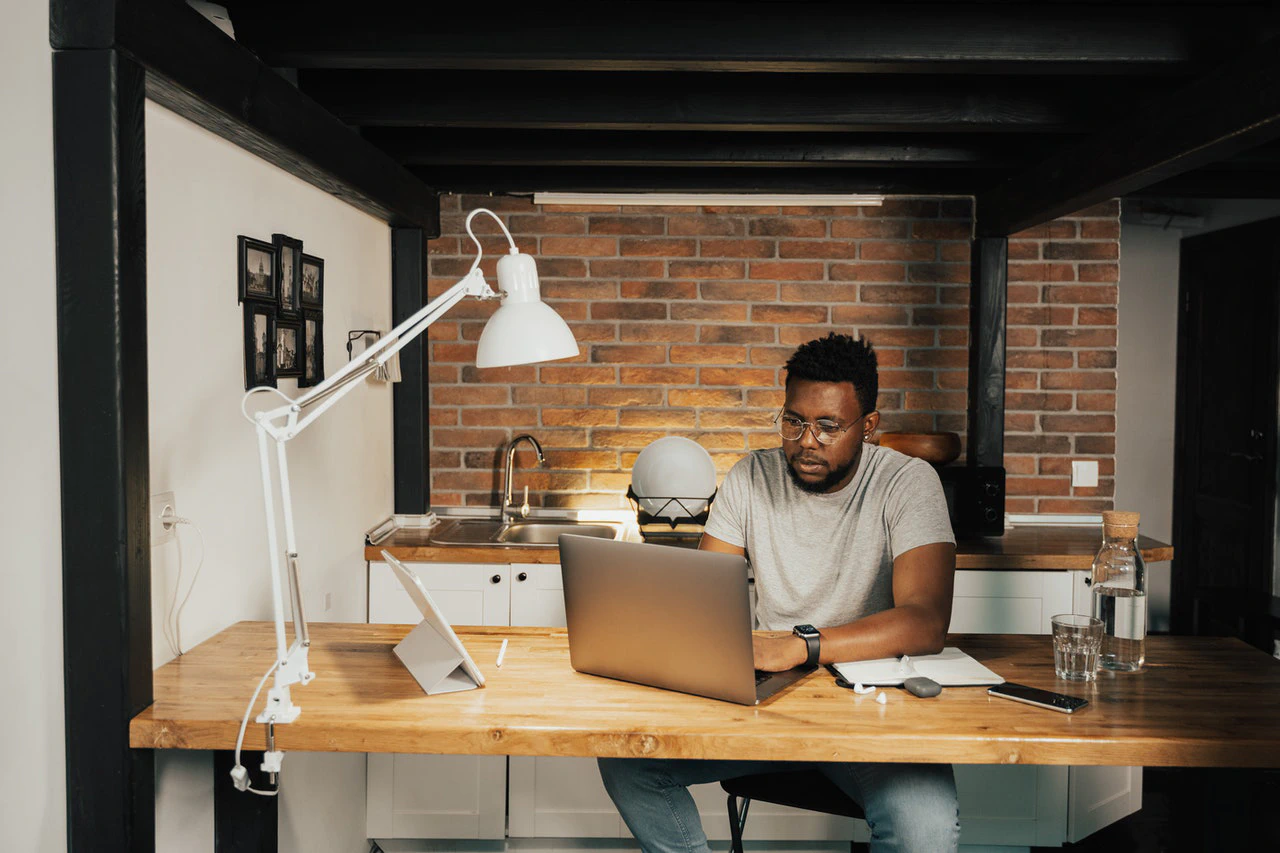 Man working at home using laptop near the big window. Remote work, online  job, work from home. Stock Photo